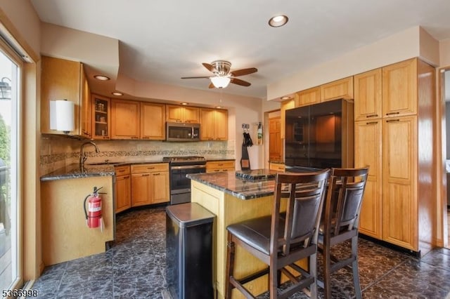 23 Midway Ct, Rockaway Twp, NJ 07866 - kitchen featuring stainless steel appliances, ceiling fan, a kitchen bar, a kitchen island, and dark stone counters