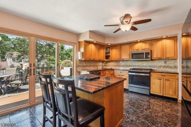 23 Midway Ct, Rockaway Twp, NJ 07866 - kitchen with stove, stainless steel microwave, brown cabinets, ceiling fan, and tasteful backsplash