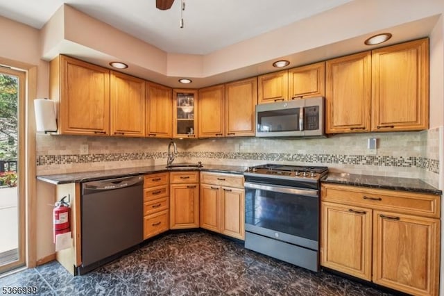 23 Midway Ct, Rockaway Twp, NJ 07866 - kitchen featuring appliances with stainless steel finishes, brown cabinetry, glass insert cabinets, ceiling fan, and tasteful backsplash