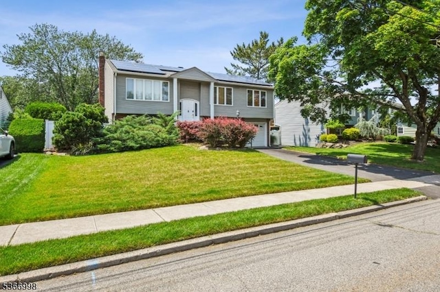 23 Midway Ct, Rockaway Twp, NJ 07866 - bi-level home featuring an attached garage, roof mounted solar panels, driveway, and a front lawn
