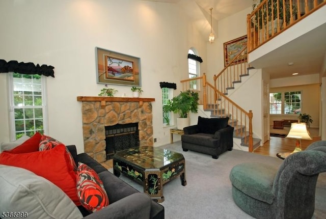 25 Watchung Trl, Branchburg Twp, NJ 08876 - carpeted living area featuring a stone fireplace, stairs, and a towering ceiling
