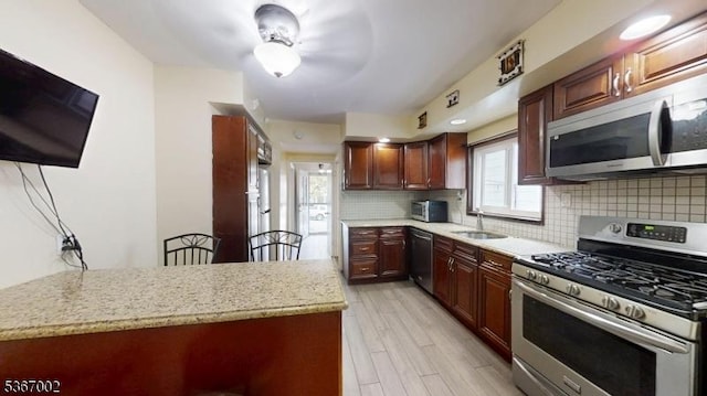 979 Lorraine Ave, Union Twp, NJ 07083 - kitchen featuring stainless steel appliances, decorative backsplash, light wood finished floors, and light stone counters