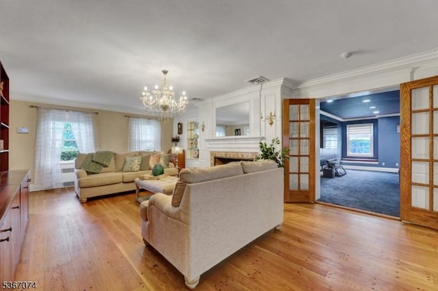 11 Clyde Ct, Bergenfield Boro, NJ 07621 - living room featuring ornamental molding, light wood finished floors, a chandelier, a fireplace, and french doors