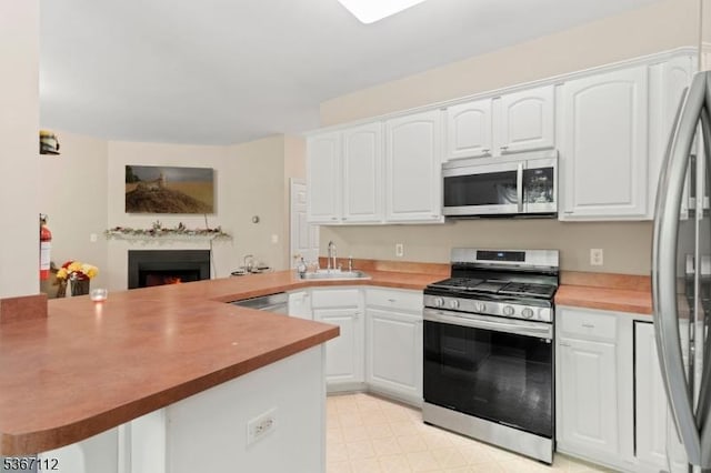 73 Pinehurst Dr, Washington Twp, NJ 07882 - kitchen featuring appliances with stainless steel finishes, a peninsula, and white cabinetry
