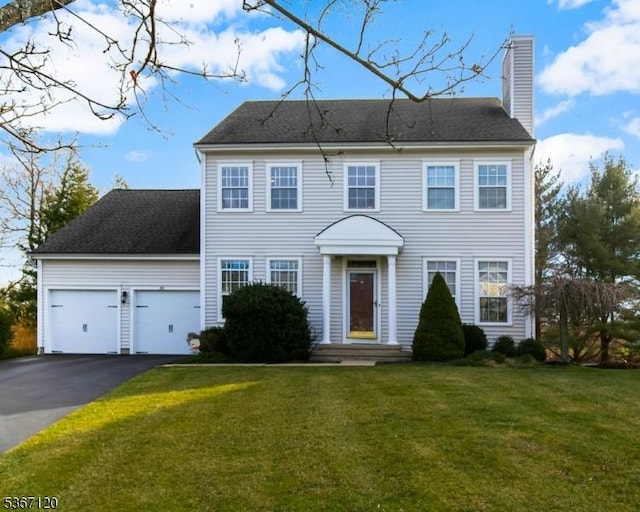 51 Carlisle Rd, Bernards Twp, NJ 07920 - colonial home featuring a chimney, driveway, an attached garage, and a front yard