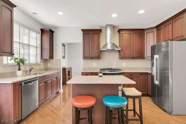 51 Carlisle Rd, Bernards Twp, NJ 07920 - kitchen featuring appliances with stainless steel finishes, wall chimney exhaust hood, light wood-style flooring, a kitchen island, and a kitchen bar