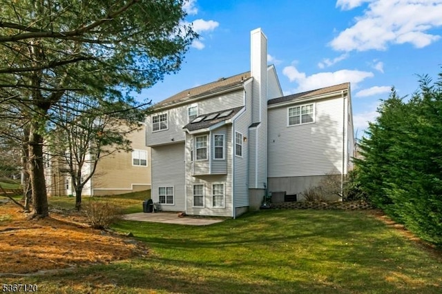 51 Carlisle Rd, Bernards Twp, NJ 07920 - back of property with a patio, a chimney, and a lawn