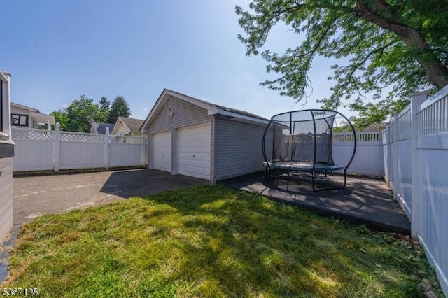 1697 Van Ness Ter, Union Twp, NJ 07083 - fenced backyard featuring a trampoline, a detached garage, and an outdoor structure