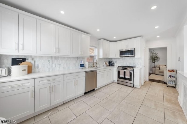 1697 Van Ness Ter, Union Twp, NJ 07083 - kitchen featuring stainless steel appliances, white cabinetry, backsplash, light countertops, and recessed lighting