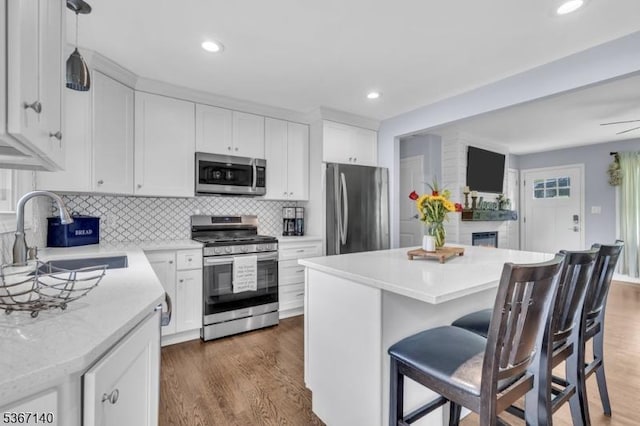 32 Mountain Heights Dr, Byram Twp, NJ 07871 - kitchen with stainless steel appliances, a breakfast bar area, a center island, wood finished floors, and recessed lighting