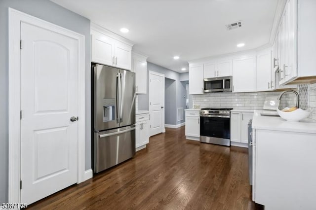 945 Wendy Ct, Union Twp, NJ 07083 - kitchen featuring stainless steel appliances, light countertops, dark wood-style flooring, tasteful backsplash, and white cabinets