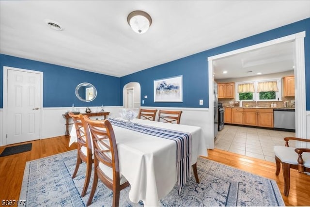 129 Francis St, Pohatcong Twp, NJ 08865 - dining space with arched walkways, wainscoting, and light wood-type flooring