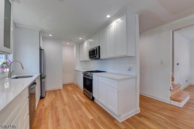 55 Florence St, Nutley Twp, NJ 07110 - kitchen with stainless steel appliances, light countertops, light wood-style floors, white cabinets, and recessed lighting
