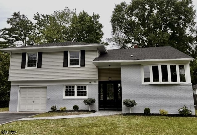 30 Runnymede Rd, Clark Twp, NJ 07066 - tri-level home with brick siding, an attached garage, a front lawn, asphalt driveway, and a chimney