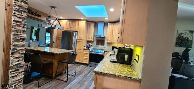 301 Ohio Ave, Pohatcong Twp, NJ 08865 - kitchen featuring stainless steel appliances, wall chimney range hood, wood finished floors, light stone countertops, and a skylight