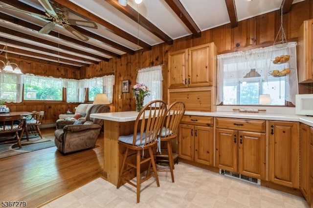 2 Hazelnut Dr, Hampton Twp, NJ 07860 - kitchen featuring beam ceiling, a ceiling fan, wood walls, light countertops, and light flooring
