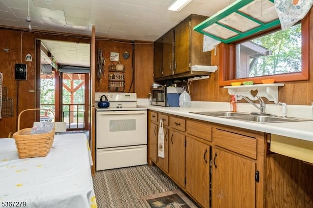 2 Hazelnut Dr, Hampton Twp, NJ 07860 - kitchen with white electric range oven, wooden walls, light countertops, stainless steel microwave, and brown cabinets