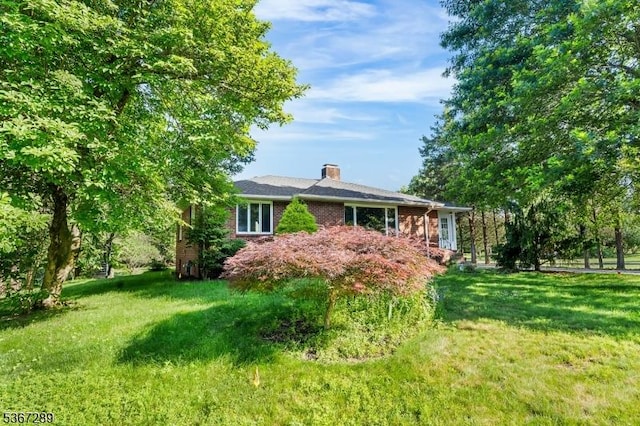 77 John E Busch Ave, Franklin Twp, NJ 08873 - view of front of home with a chimney, brick siding, and a front lawn
