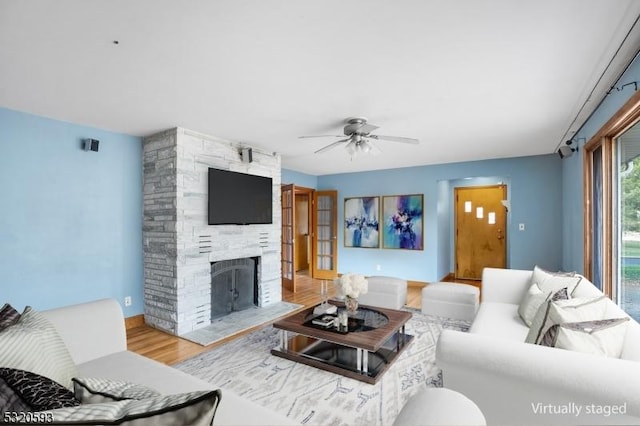 77 John E Busch Ave, Franklin Twp, NJ 08873 - living area with wood finished floors, ceiling fan, and a stone fireplace