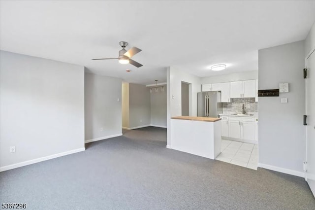 412-432 Broad Way Unit 25A, Passaic City, NJ 07055 - kitchen with freestanding refrigerator, light carpet, white cabinets, a ceiling fan, and tasteful backsplash
