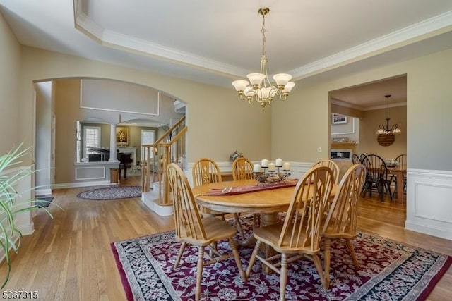 3 Mackenzie Ct, Sparta Twp, NJ 07871 - dining area featuring arched walkways, a chandelier, wood finished floors, ornamental molding, and a wainscoted wall