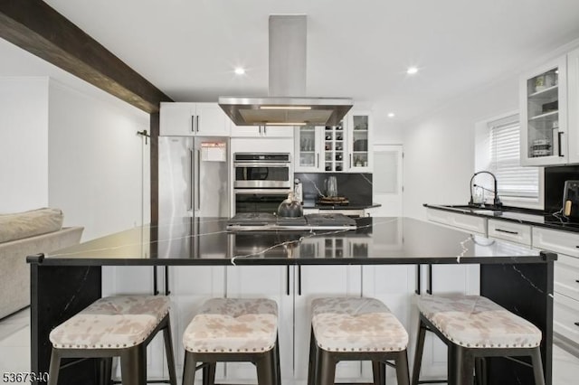 28 Sanford Ave, Belleville Twp, NJ 07109 - kitchen featuring island range hood, stainless steel appliances, dark countertops, white cabinets, and glass insert cabinets