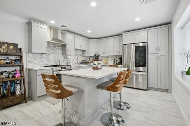 28 Sanford Ave, Belleville Twp, NJ 07109 - kitchen featuring appliances with stainless steel finishes, wall chimney exhaust hood, a kitchen breakfast bar, light countertops, and backsplash