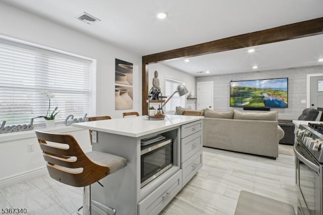28 Sanford Ave, Belleville Twp, NJ 07109 - kitchen with stainless steel appliances, a center island, light countertops, beamed ceiling, and open floor plan