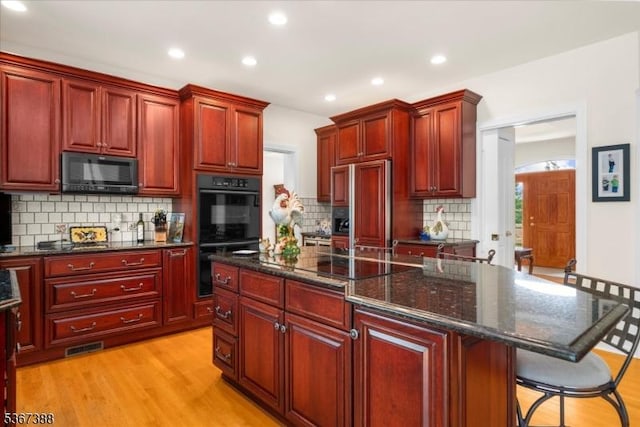 3 Stanbury Ln, Kingwood Twp, NJ 08825 - kitchen with black appliances, reddish brown cabinets, decorative backsplash, recessed lighting, and a center island