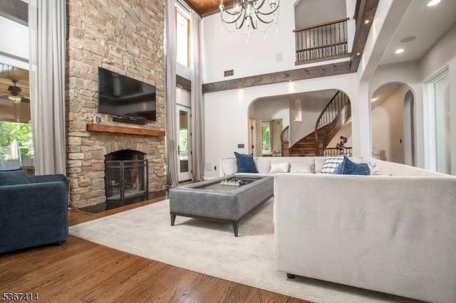 39 Crescent Dr, Morris Twp, NJ 07960 - living room with wood finished floors, a fireplace, arched walkways, a high ceiling, and stairway