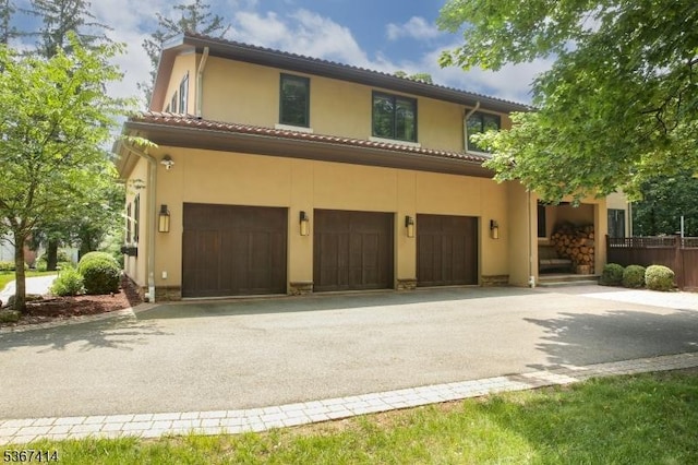 39 Crescent Dr, Morris Twp, NJ 07960 - mediterranean / spanish home featuring an attached garage, driveway, a tile roof, and stucco siding