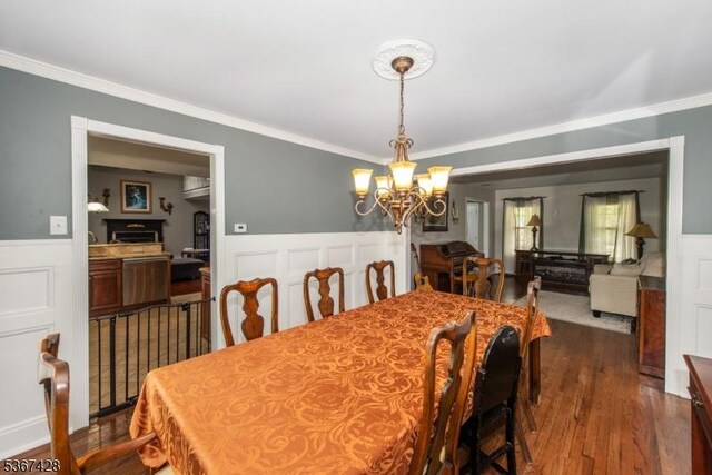 14 Windjammer Dr, Jefferson Twp, NJ 07849 - dining area featuring a chandelier, ornamental molding, a wainscoted wall, dark wood-style floors, and a decorative wall