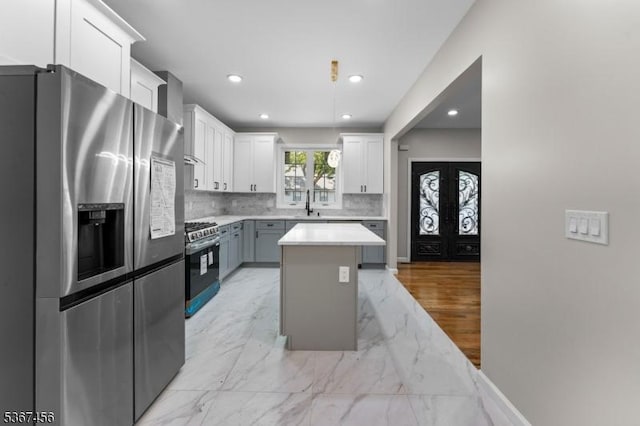 331 W Ln, Clark Twp, NJ 07066 - kitchen featuring appliances with stainless steel finishes, backsplash, a kitchen island, white cabinetry, and light countertops