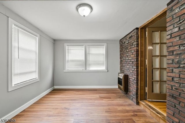 917 Tompkins Ave, South Plainfield Boro, NJ 07080 - unfurnished living room with a brick fireplace, light wood-style flooring, heating unit, and brick wall