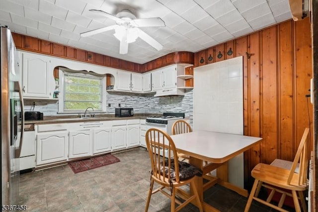 917 Tompkins Ave, South Plainfield Boro, NJ 07080 - kitchen featuring decorative backsplash, ceiling fan, open shelves, wooden walls, and under cabinet range hood