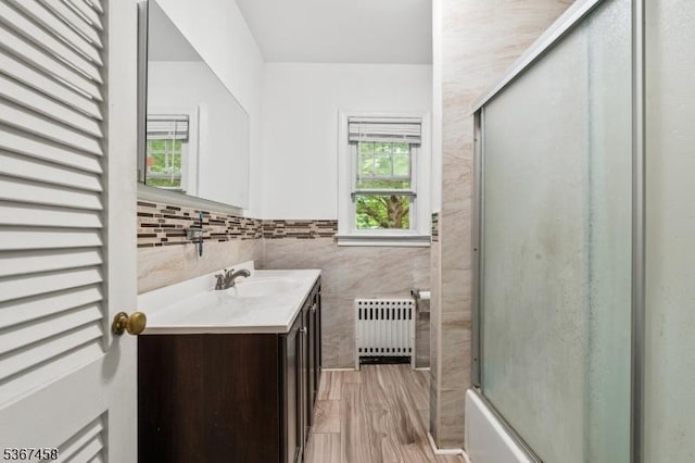 917 Tompkins Ave, South Plainfield Boro, NJ 07080 - full bathroom featuring radiator, vanity, tile walls, and bath / shower combo with glass door