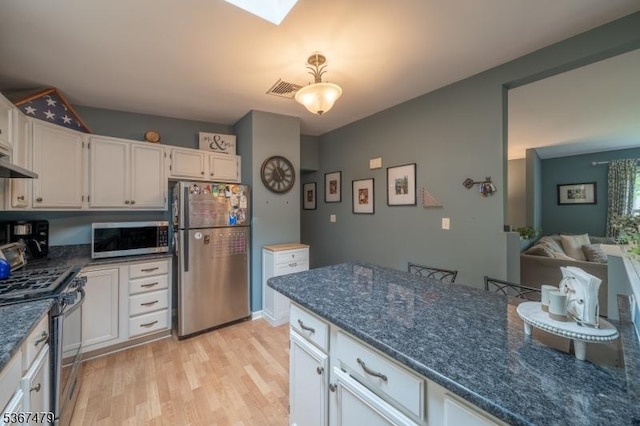 37 Evergreen Rd, Vernon Twp, NJ 07461 - kitchen with appliances with stainless steel finishes, light wood-type flooring, white cabinets, dark stone counters, and a skylight