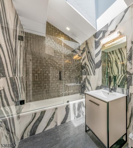 17 Glenwood Rd, Colts Neck Twp, NJ 07722 - bathroom with a combined bath / shower with marble appearance, vanity, vaulted ceiling, and a baseboard radiator