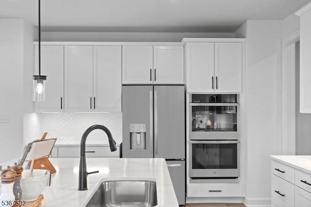 14 Glacier Way, Union Twp, NJ 08867 - kitchen with stainless steel appliances, light countertops, white cabinets, hanging light fixtures, and tasteful backsplash