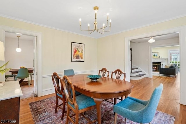 329 W End Rd, South Orange Village Twp, NJ 07079 - dining area with ornamental molding, light wood-style floors, a chandelier, and a lit fireplace