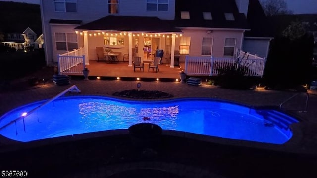 10 Links Ct, Sparta Twp, NJ 07871 - pool at night featuring a hot tub, an outdoor pool, a deck, and a patio