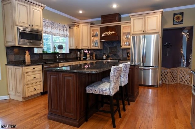 10 Links Ct, Sparta Twp, NJ 07871 - kitchen with appliances with stainless steel finishes, cream cabinets, ornamental molding, light wood finished floors, and a kitchen island