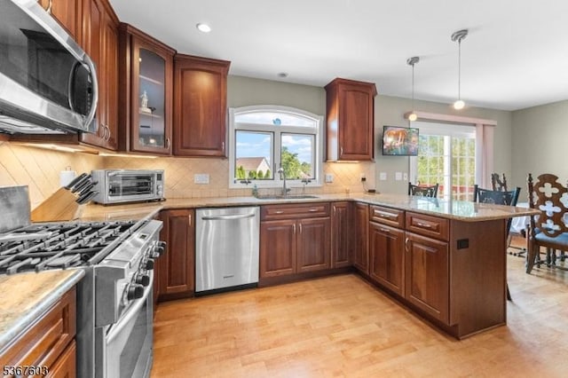 26 Ditmars Cir, Hillsborough Twp, NJ 08844 - kitchen with appliances with stainless steel finishes, decorative backsplash, a peninsula, light wood-style floors, and light stone counters