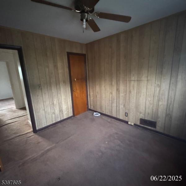 35 Eastern Pkwy, Hillside Twp, NJ 07205 - carpeted empty room with a ceiling fan and wooden walls