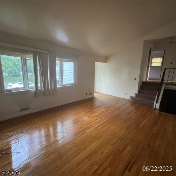 35 Eastern Pkwy, Hillside Twp, NJ 07205 - unfurnished living room featuring wood finished floors and stairs