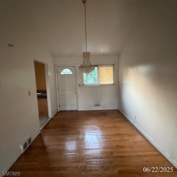 35 Eastern Pkwy, Hillside Twp, NJ 07205 - unfurnished dining area with wood finished floors and a chandelier
