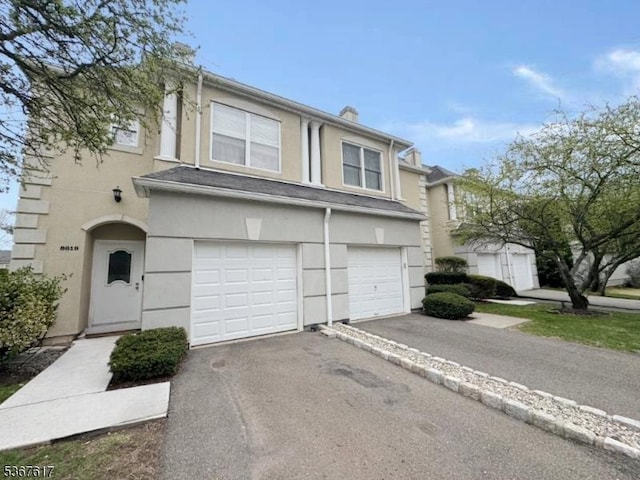 8619 Brittany Dr, Wayne Twp, NJ 07470 - view of front of property featuring stucco siding, a garage, and asphalt driveway