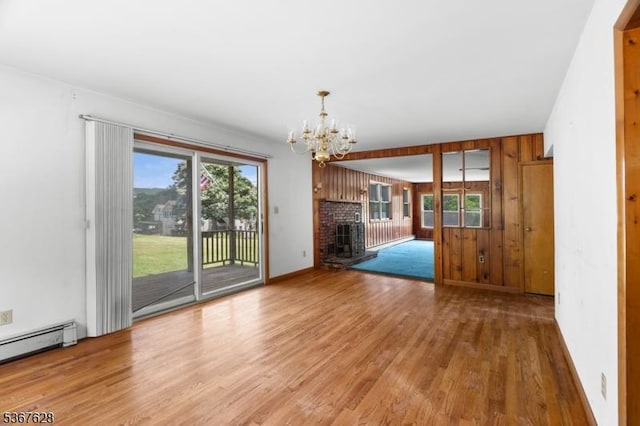 150 Buckley Ave, Oxford Twp, NJ 07863 - unfurnished living room with light wood-style flooring, a chandelier, a fireplace, a baseboard heating unit, and wooden walls