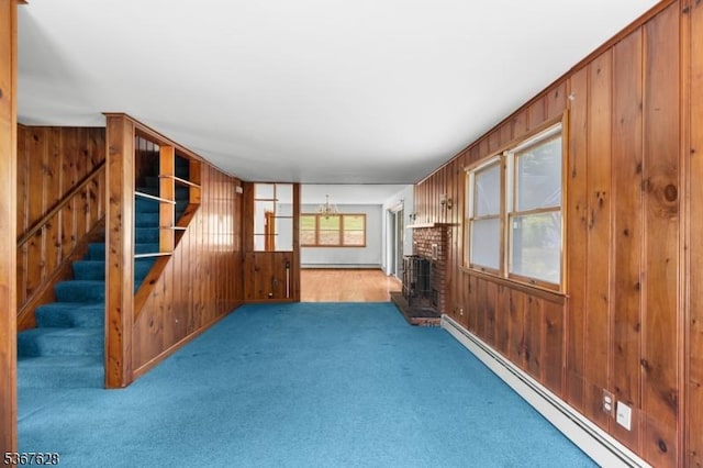 150 Buckley Ave, Oxford Twp, NJ 07863 - unfurnished living room featuring a baseboard heating unit, wooden walls, carpet floors, stairs, and a fireplace