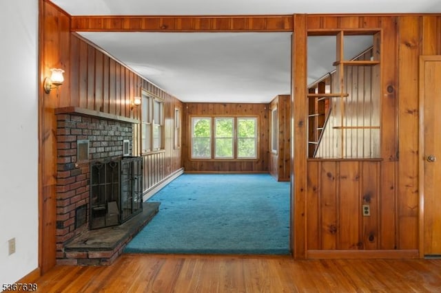 150 Buckley Ave, Oxford Twp, NJ 07863 - unfurnished living room featuring a fireplace, wood finished floors, wood walls, and carpet floors